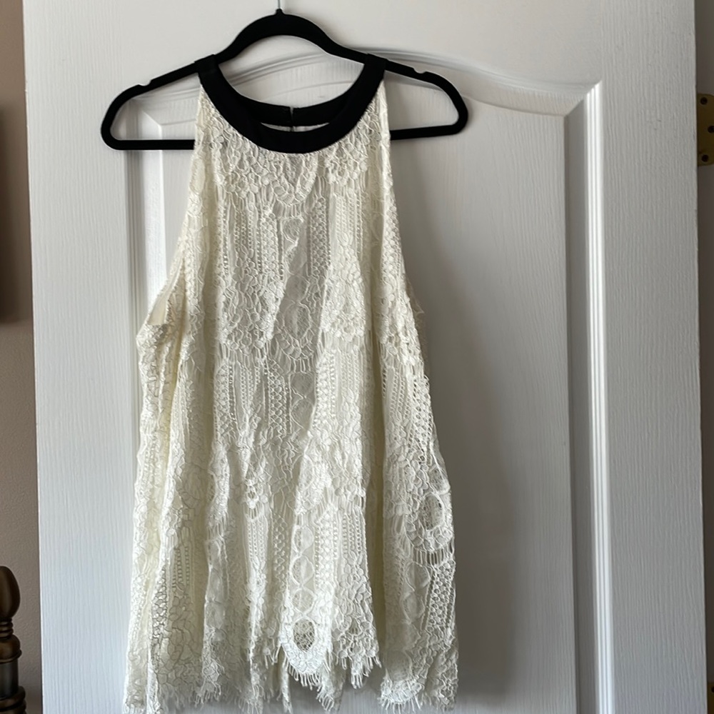 Cream color lace top with black trim and black bow in back